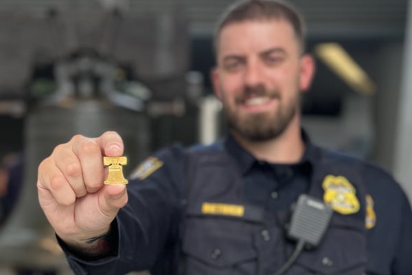 Mint Police Officer Holding Liberty Bell Coin