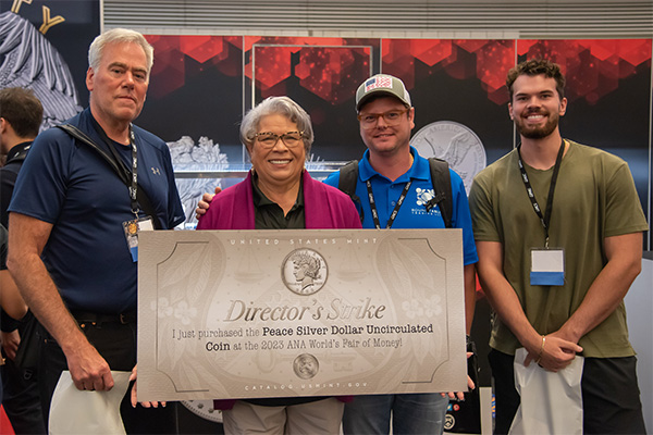 Former Mint Director Ventris C. Gibson holds a sign at the 2023 ANA World's Fair of Money, an annual convention held by the American Numismatist Association. 