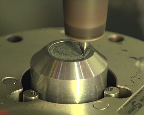 machine engraving the design onto the master hub