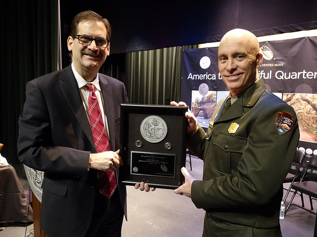 Two men holding a shadow box frame between them