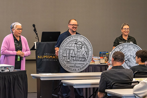 Director Gibson and two others speak in front of a group