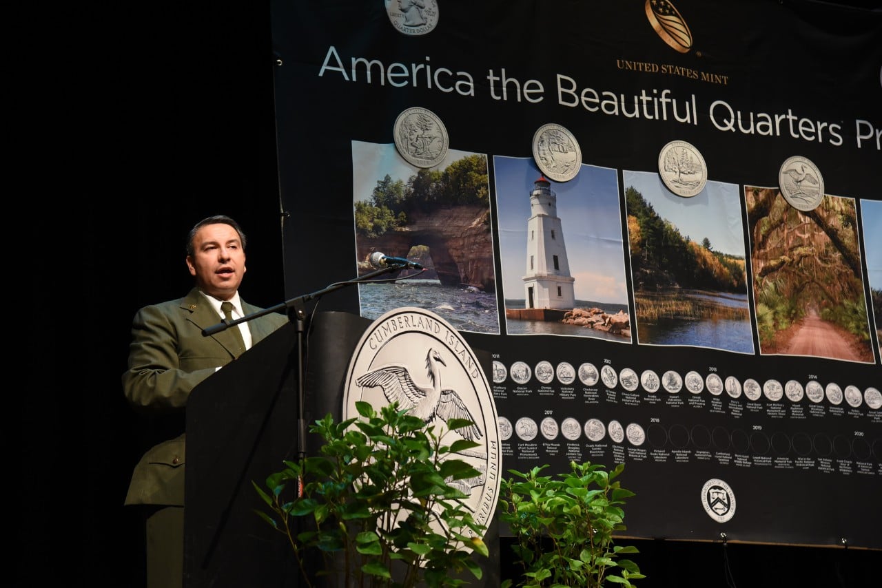 National Park Service employee stands at a podium in front of an ATB banner