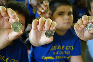 Children hold up their new Everglades National Park quarters.