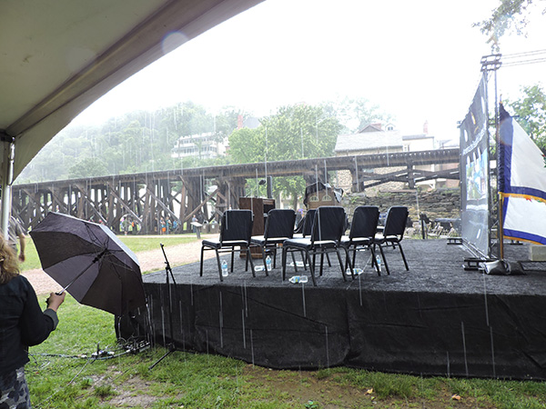 A sudden downpour sends audience running for cover. The ceremony resumed after the storm passed.