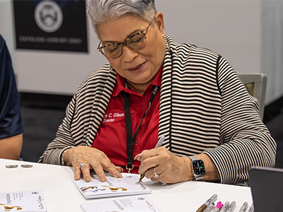 Director Gibson signing paper inserts