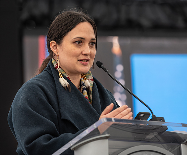 Lily Gladstone speaking at the podium of the Maria Tallchief Quarter event.