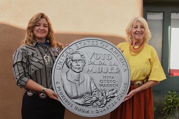 two women holding a coin board