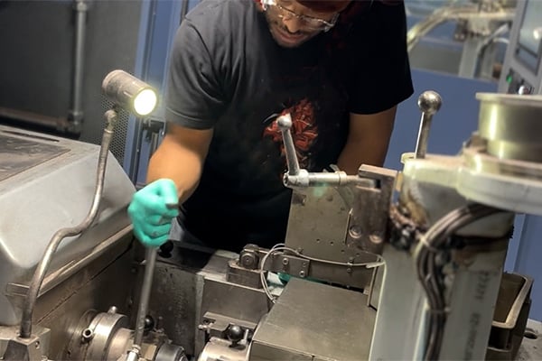 Anthony Teagle using a tool inside a coin press