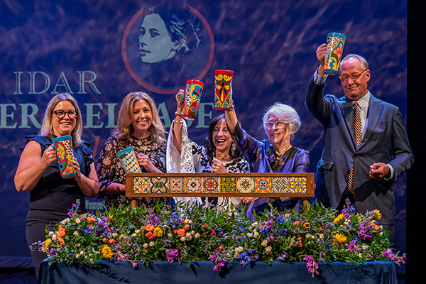 U.S. Mint Deputy Director Kristie McNally stands next to four people holding Mexican-tiled cups.