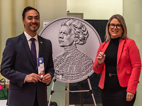 U.S. Rep. Joaquin Castro and U.S. Mint Deputy Director Kristie McNally stand on either side of a Jovita Idar Quarter poster.
