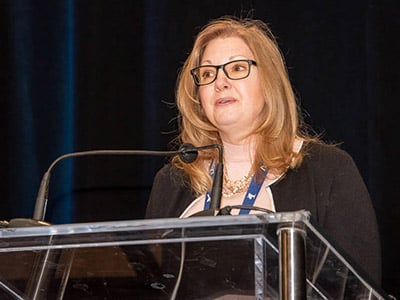Michele Thompson speaking at a podium