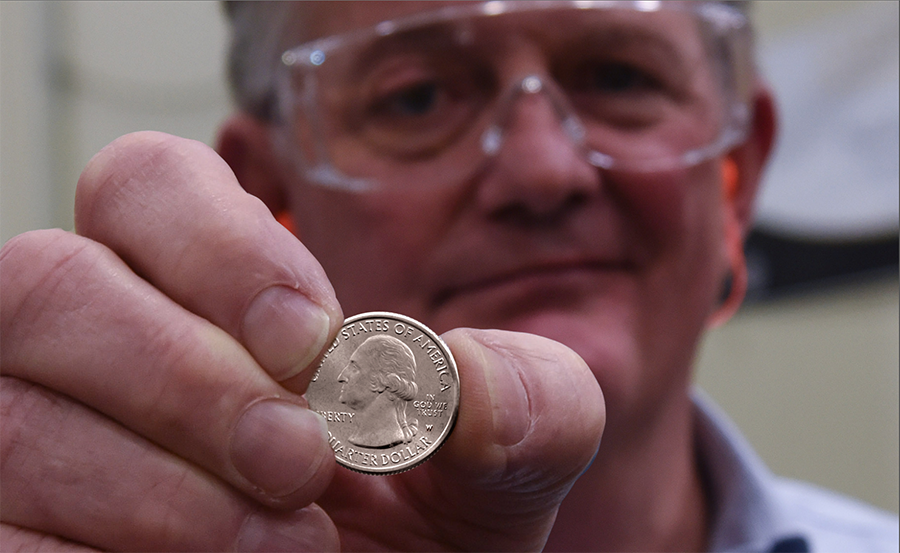 Director Ryder holds up a 2019 America the Beautiful quarter obverse with W mint mark