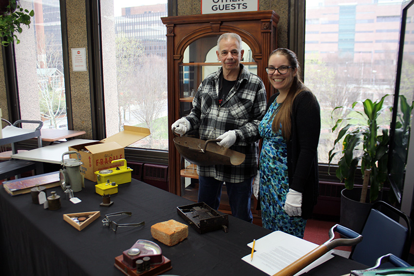Philadelphia Mint employees holding a historic coin scoop