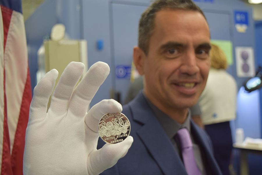 LeRoy Transfield, the winning artist who designed the World War I Centennial Silver Dollar, holds a newly-minted WWI Centennial Silver Dollar.