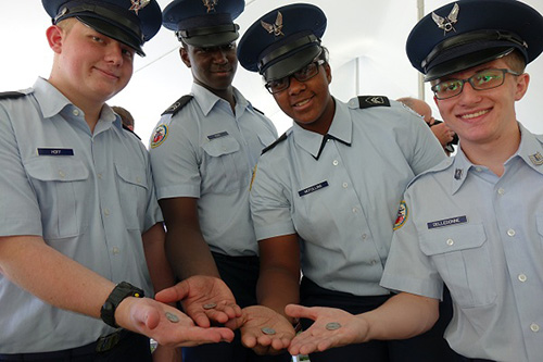 Members of the Smyrna High School JROTC proudly hold their new quarters following the Bombay Hook National Wildlife Refuge quarter launch on Sept. 18, 2015, in Smyrna, DE. U.S. Mint photo by Sharon McPike.