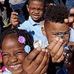children holding up coins