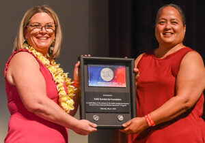 U.S. Mint Deputy Director Kristie McNally holds a shadowbox with a representative of the Edith Kanakaʻole Foundation.