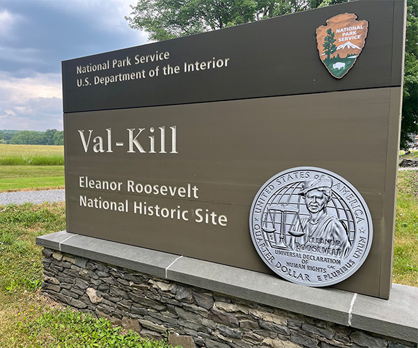 Val-Kill Eleanor Roosevelt National Historic Site sign with Eleanor Roosevelt Quarter poster in front